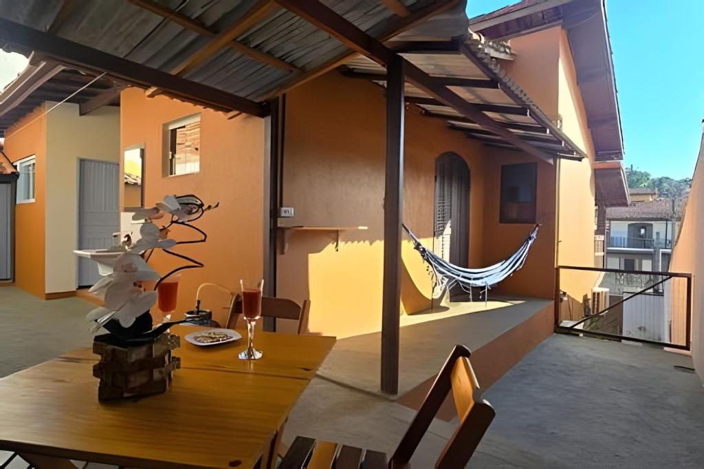 a patio with a wooden table on a house at Chalé Ilhamar c/ garagem in Ilhabela