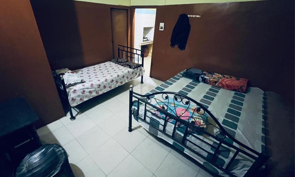 two twin beds in a room with at Foothill Lodge in Guwahati