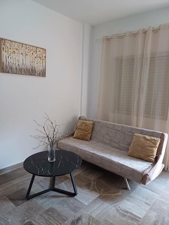 a living room with a couch and a table at Cozy Corner Heraklion in Thérissos
