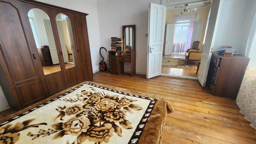 a living room with a rug on a wooden floor at Gabe's house in Zugdidi