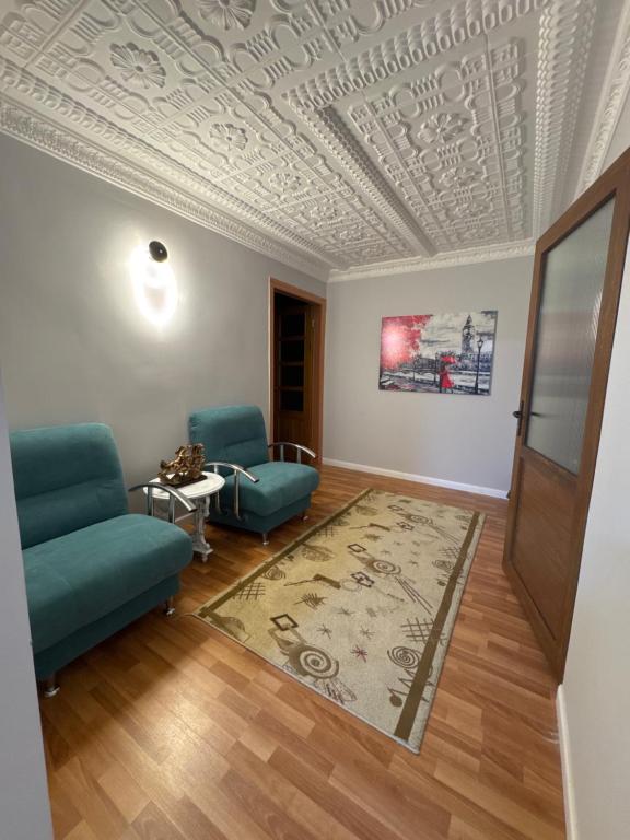 a living room with a couch and a table and a ceiling at Ho5tel House in Shymkent