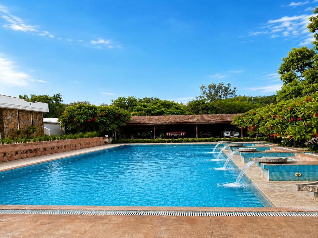 a swimming pool with water fountains at DanCenter Kolpol by CheckIn Udaipur in Udaipur