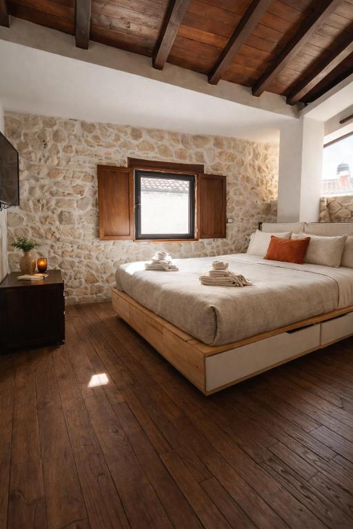 a bedroom with a large bed and a stone wall at CASA DI Noris in Fiuggi