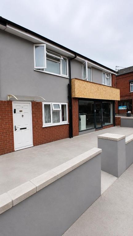 a house with a patio and a building at Unique private rooms (1) in Bolton