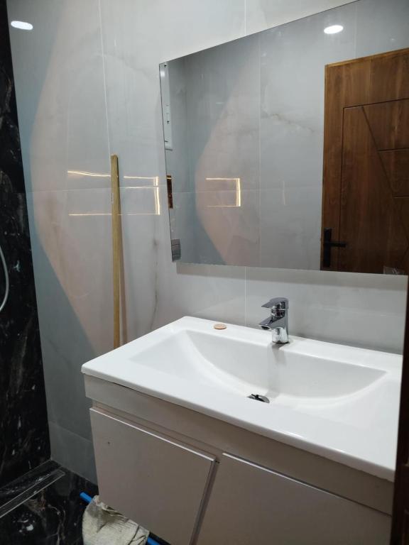 a bathroom with a white sink and a mirror at Appartement lemjid in Kelibia