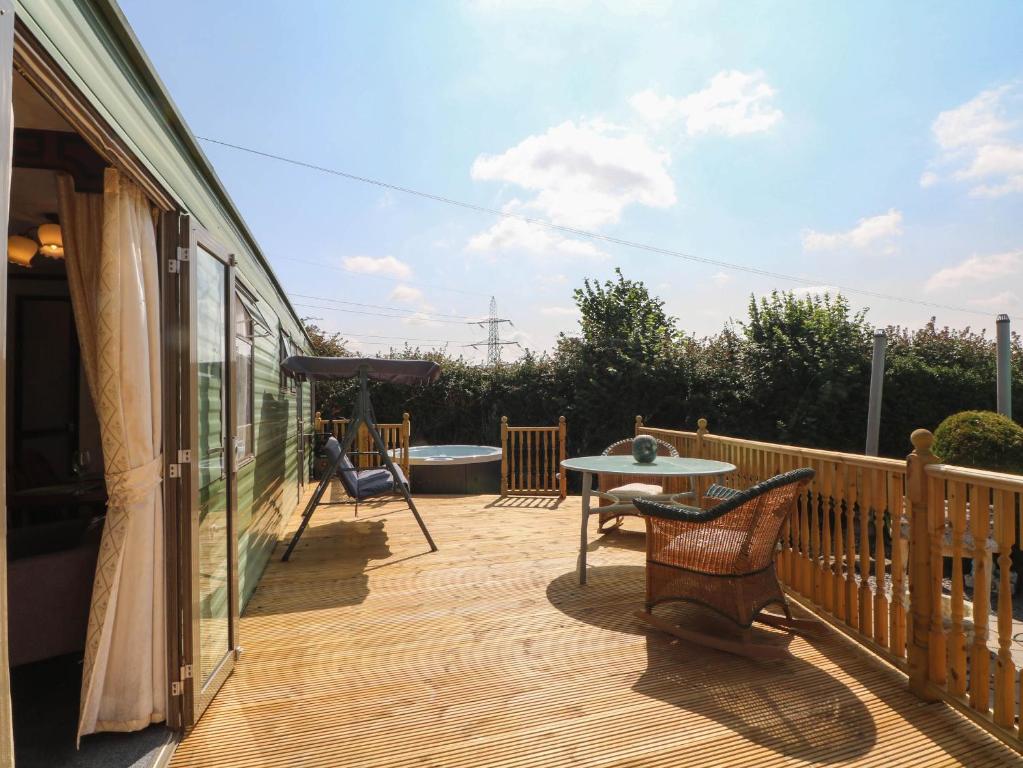 a patio with chairs and a table on a deck at Buzzards Retreat in Wrexham