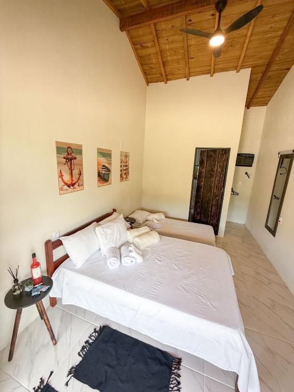 a bedroom with a large bed and a table at Hospedagem Ratzke in Paraty