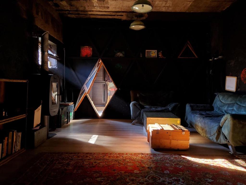 a dark room with a room with a couch and a window at K7- Bunker in Kapan