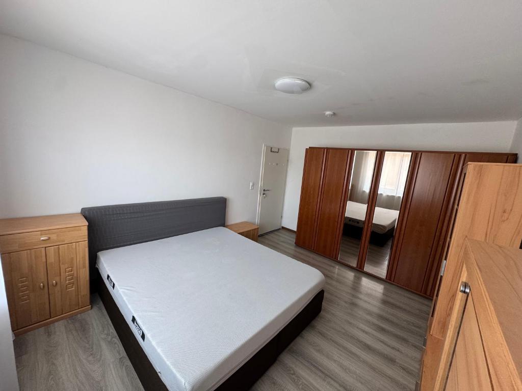 a small bedroom with a bed and wooden cabinets at Landshuter str 17 in Straubing