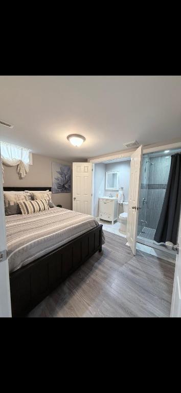 a bedroom with a large bed and a bathroom at BASEMENT APARTMENT Two Bedrooms in Whitby