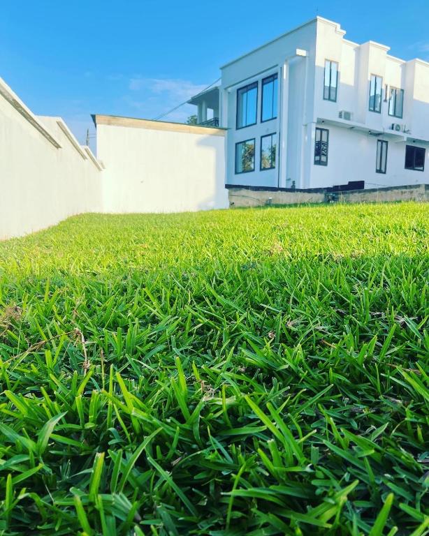 a yard with green grass in front of a house at Afse apartments Peduase in Aburi
