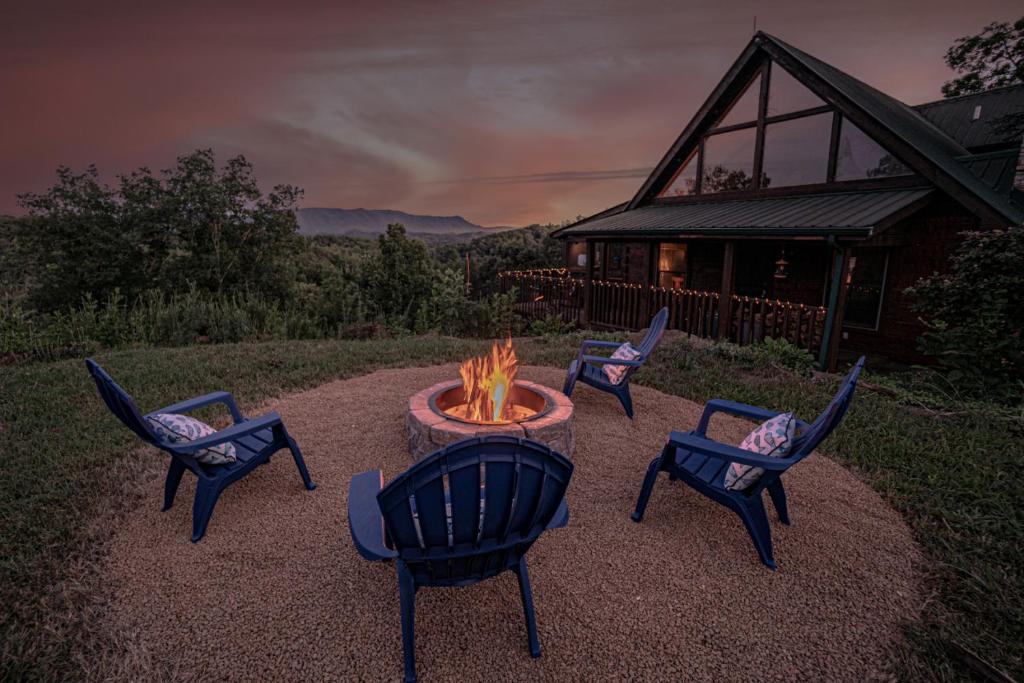 a group of chairs around a fire pit in front of a house at Poppy’s Place Cabin in Dandridge