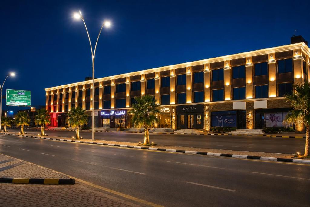 an empty street in front of a building at night at Leaf Suites - أجنحة ليف in Ar Rass