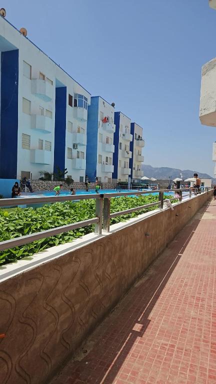 a retaining wall next to a sidewalk and buildings at Appartement de vacance à Tanmia Bloc 13 in Martil