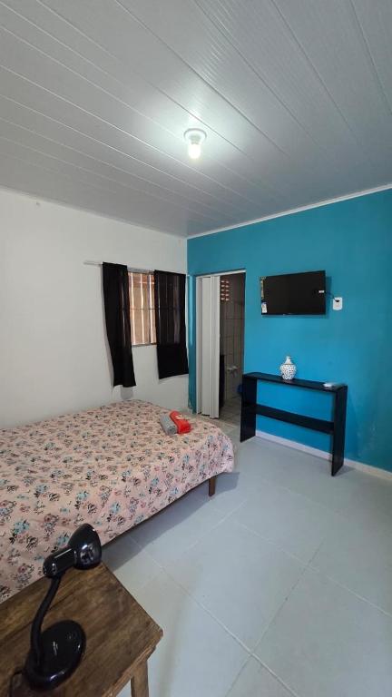 a bedroom with a bed and a table in it at Acomodações as casinhas da ada in Coruripe