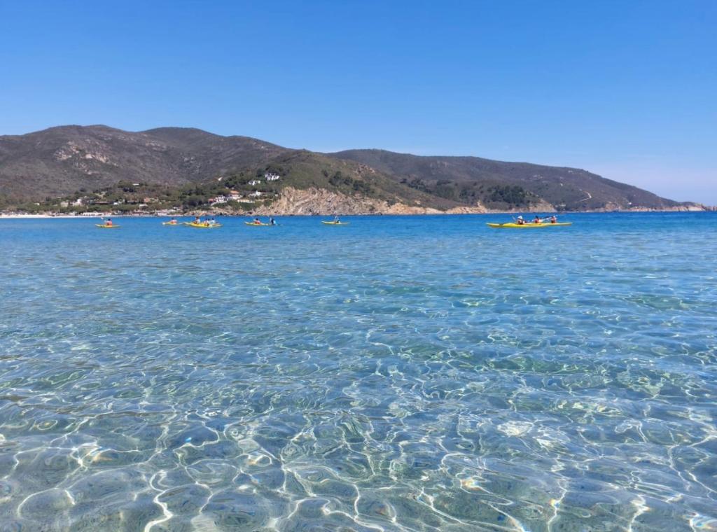 a group of people in boats in the water at Appartamenti L'Arcipelago in Marina di Campo