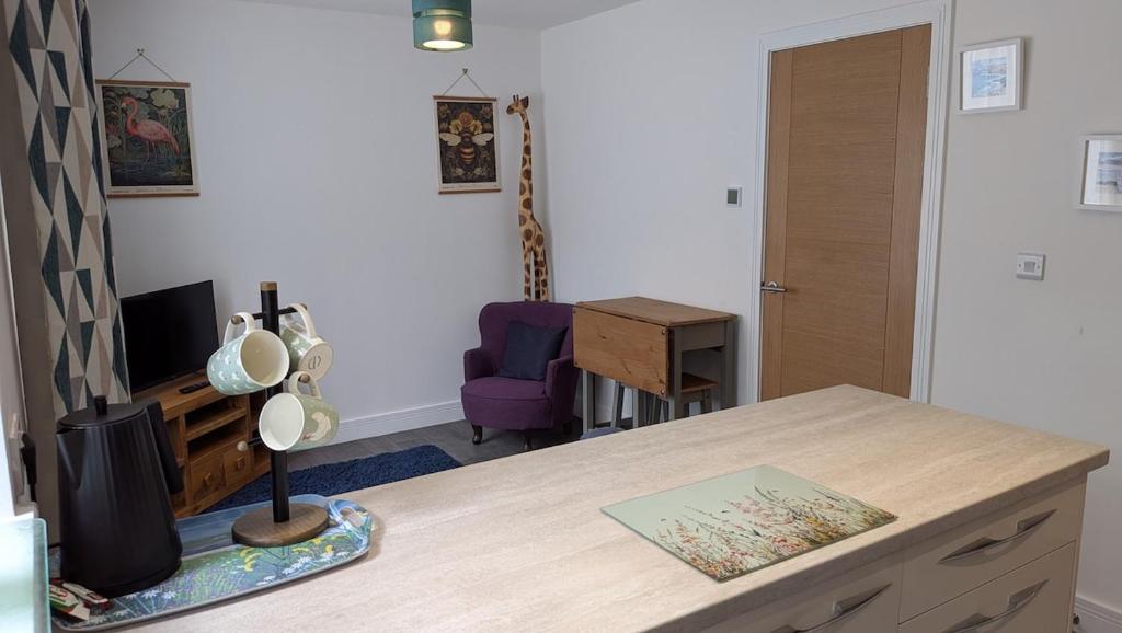 a kitchen with a table and a desk with a chair at The Annexe in West Buckland