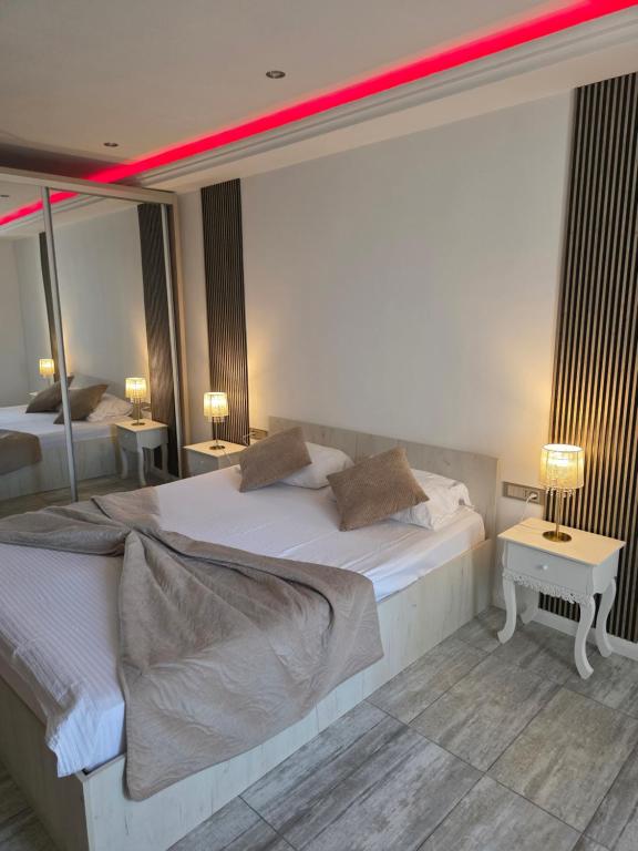 a bedroom with two beds and two lamps and a mirror at Smart Apartament in Brăila
