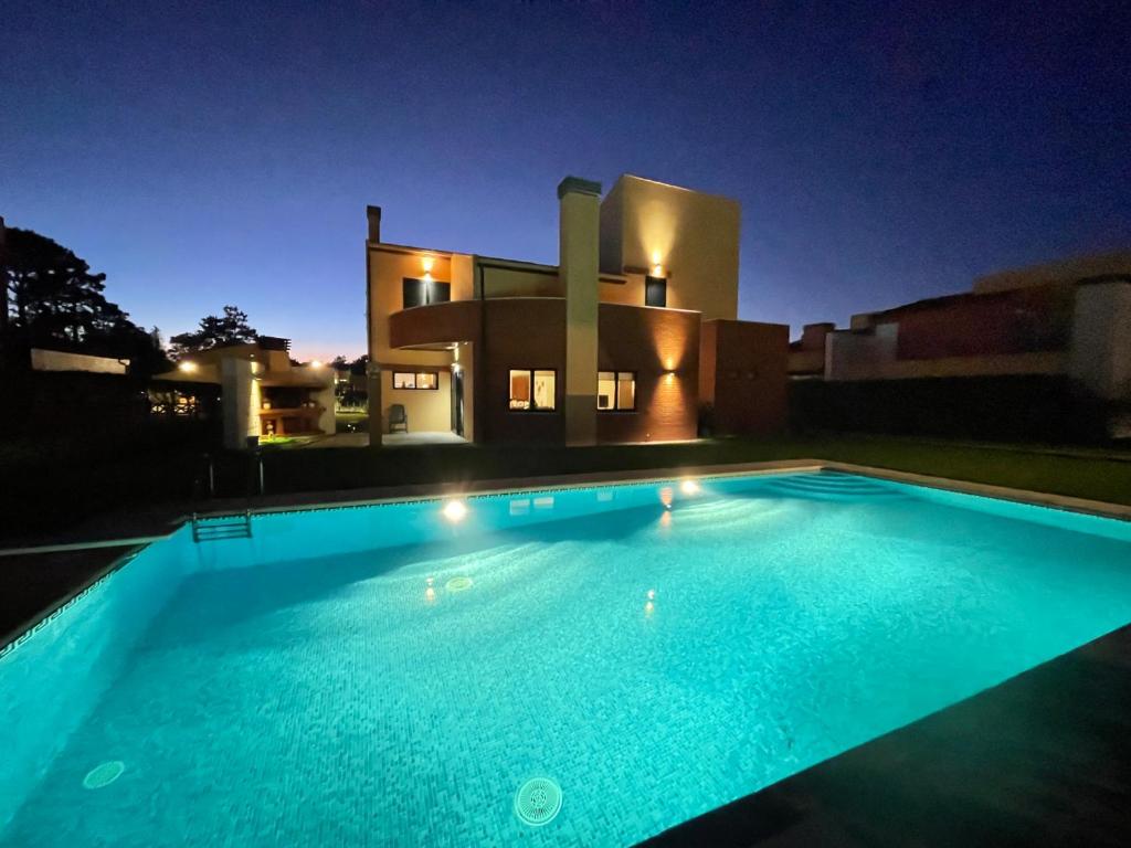 a swimming pool in front of a house at night at Villa Fernandos in Praia de Mira