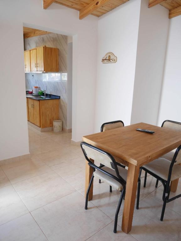 a dining room with a wooden table and chairs at Ayinmai departamento C in Trelew