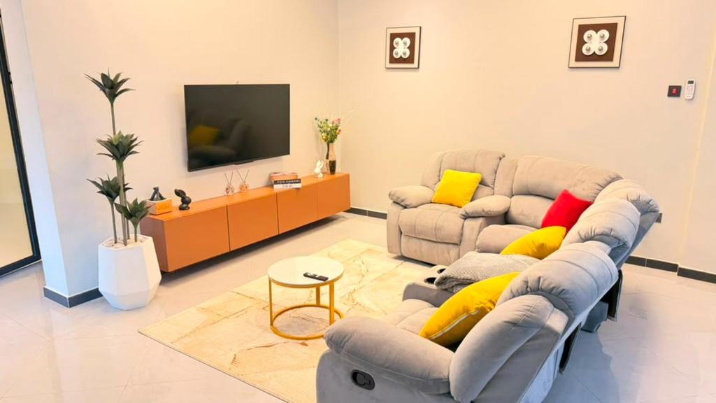 a living room with two couches and a tv at EZER HOMEs in Kampala
