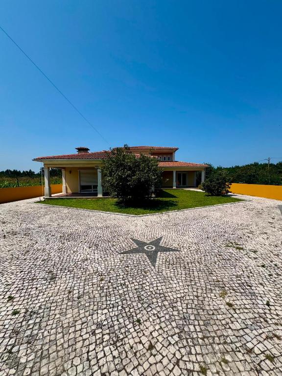 a star on the ground in front of a house at West Gold in Praia de Mira