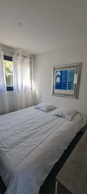 a large white bed in a room with two windows at Les chambres de Dolce in Bandol