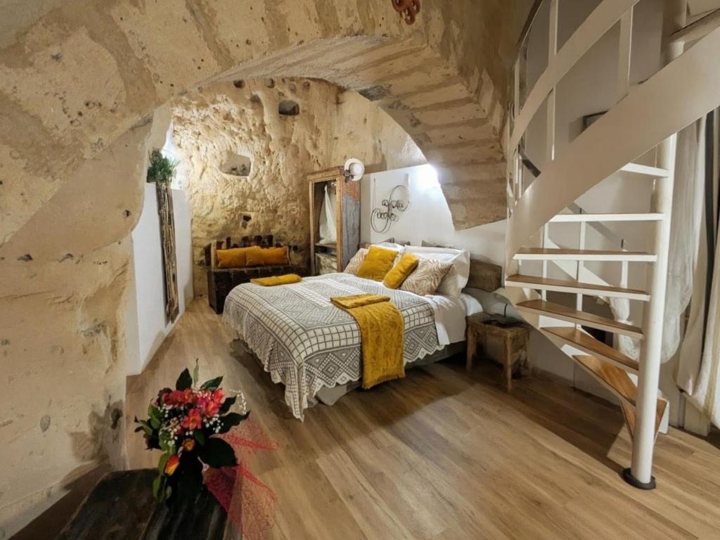 a bedroom with a bed in a stone wall at Il Geco in Matera