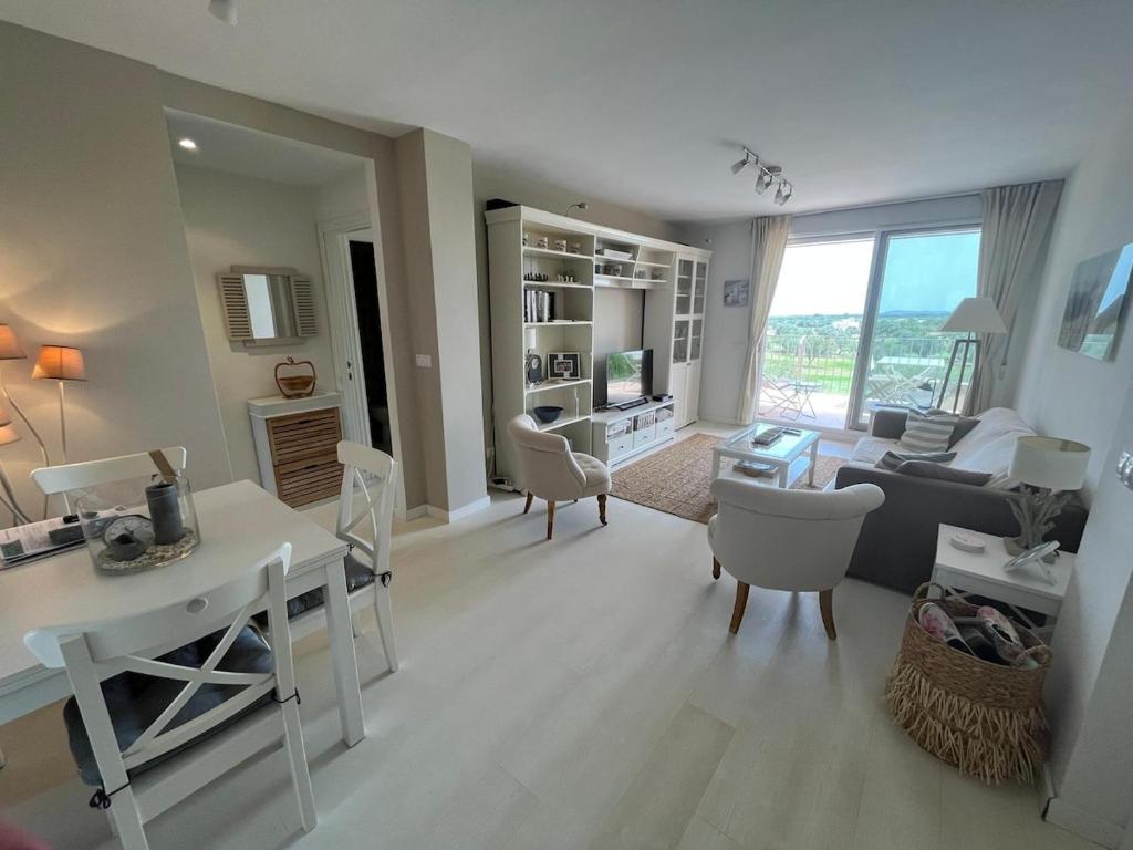 a living room with a white table and chairs at Condo with golf course views, pool and terraces in San Jorge