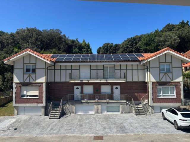a house with solar panels on top of it at Apartamentos La Reserva Isla "Playa de la Cava" in Isla