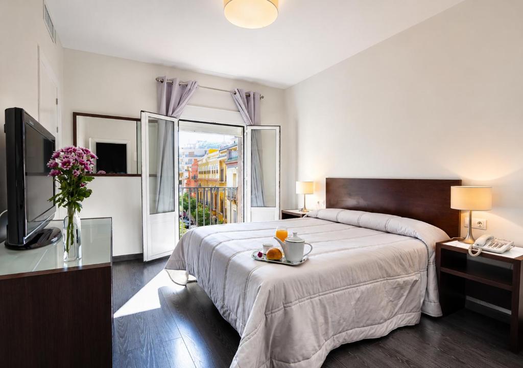 a bedroom with a large bed and a window at Hotel Madrid de Sevilla by SHS in Seville