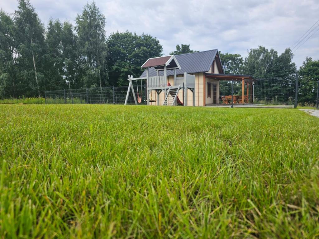 a house in the middle of a field with a playground at Przystanek Semlin - Za Jeziorem in Semlin
