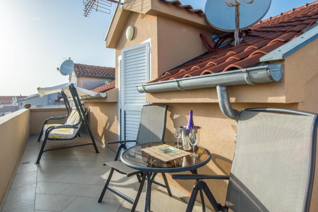 a patio with two chairs and a table on a balcony at Apartments Domuzin in Biograd na Moru