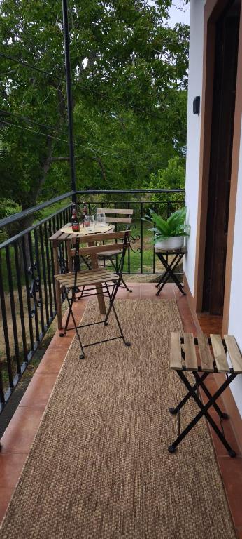 a balcony with a table and benches on a porch at O retiro da Trabe in Viveiro