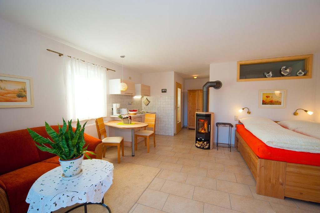 a bedroom with a bed and a living room at Ferienwohnung Gänseblümchen in Suhl