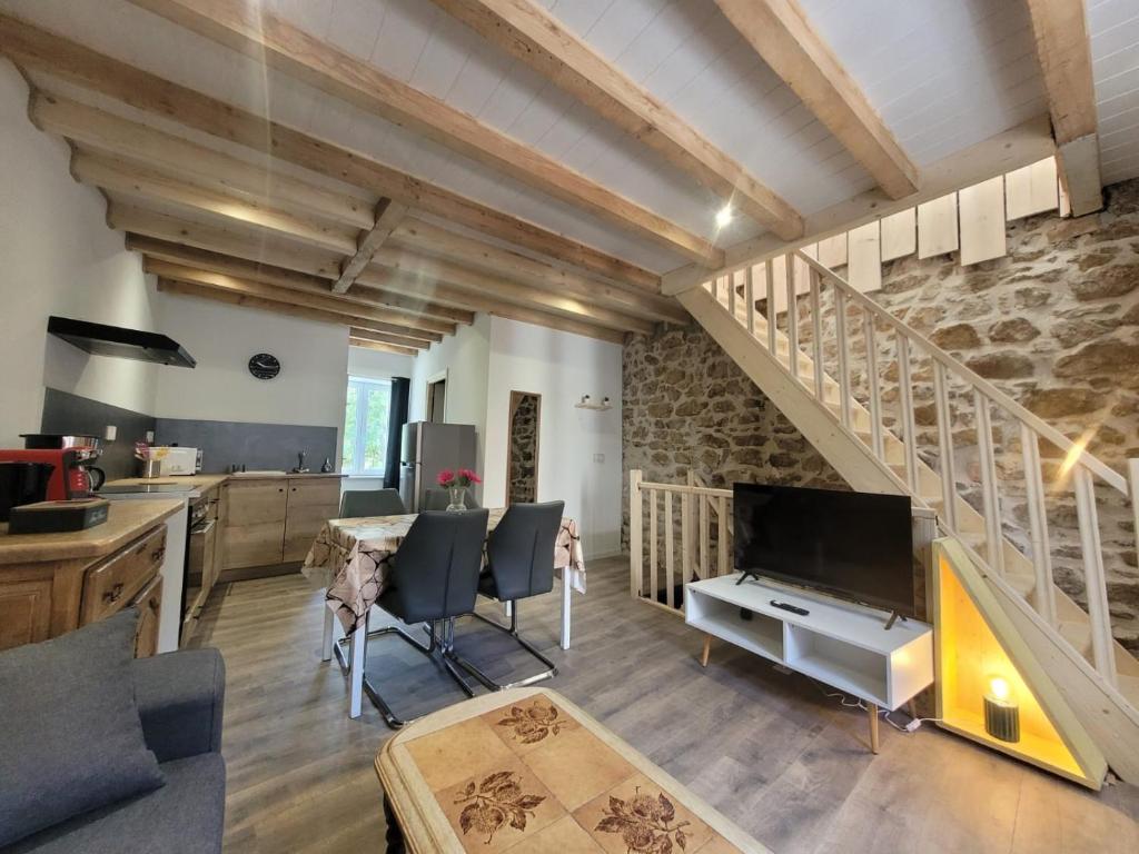 a kitchen and living room with a stone wall at Duplex des Volcans in Montaigut-le-Blanc
