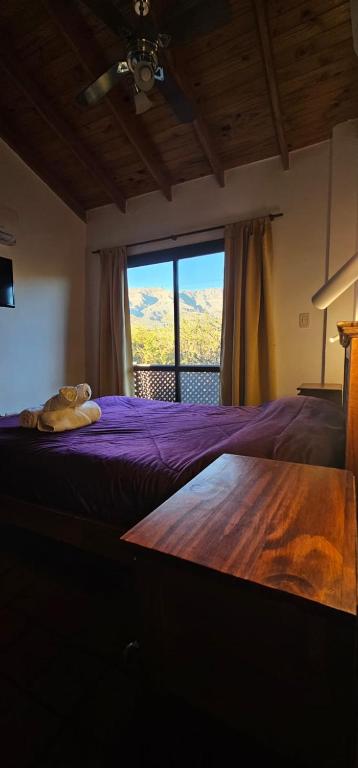 a bedroom with a purple bed with a large window at Complejo los Espinillos de Merlo in Merlo