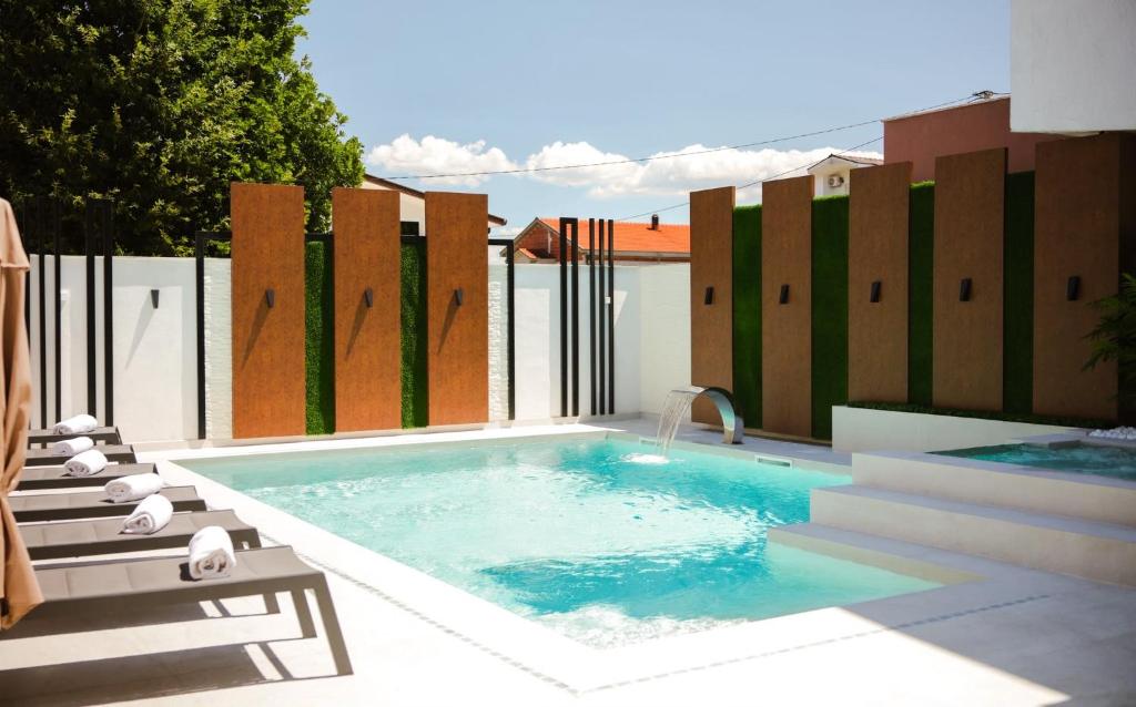 a swimming pool on a patio with a fence at Hotel San Međugorje in Čitluk