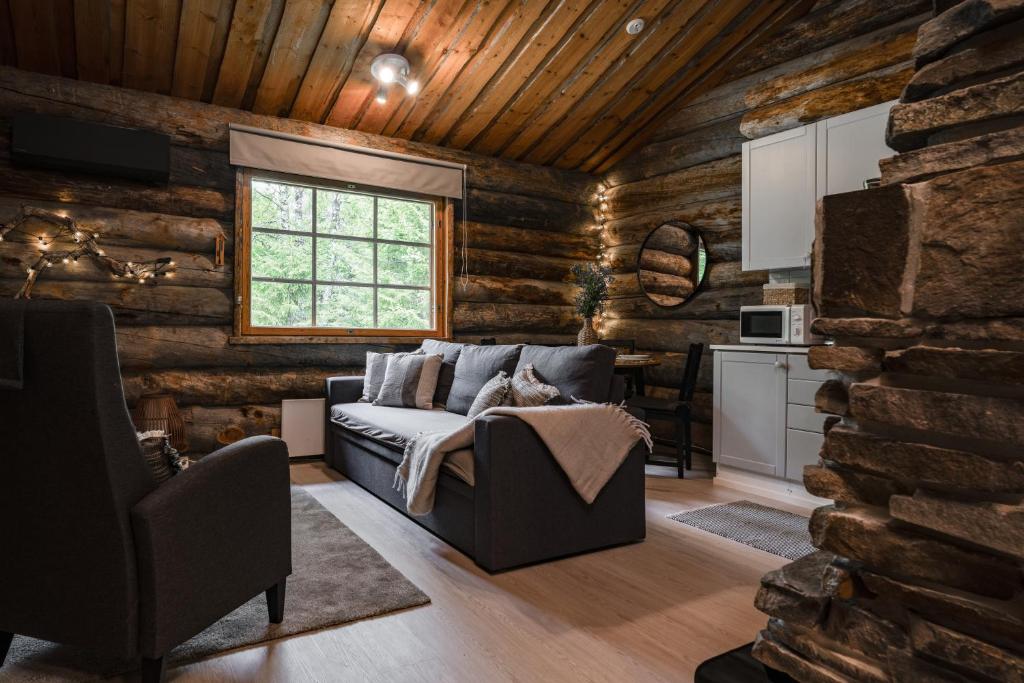 a living room with a couch in a log cabin at Rukan Lumikelo in Kuusamo