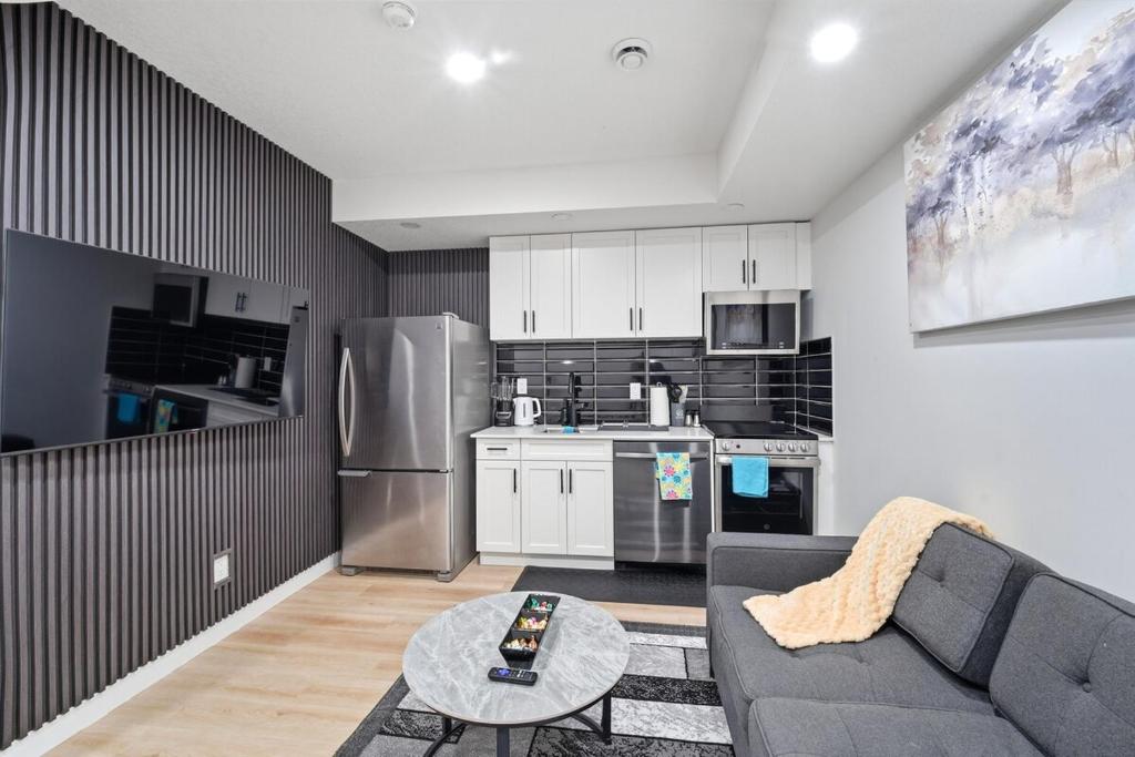 a living room with a couch and a kitchen at Suite in Ambleton - Calgary in YYC