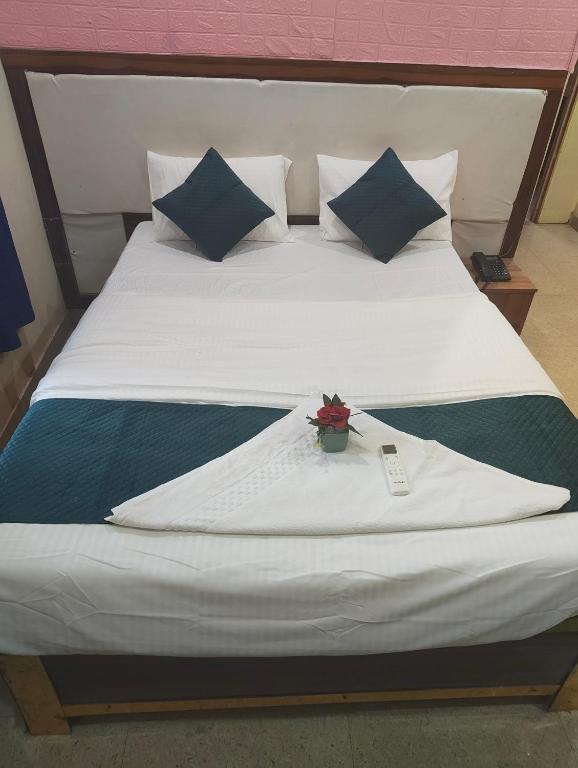 a white bed with a plant on top of it at Woohoo Hotels in Patna