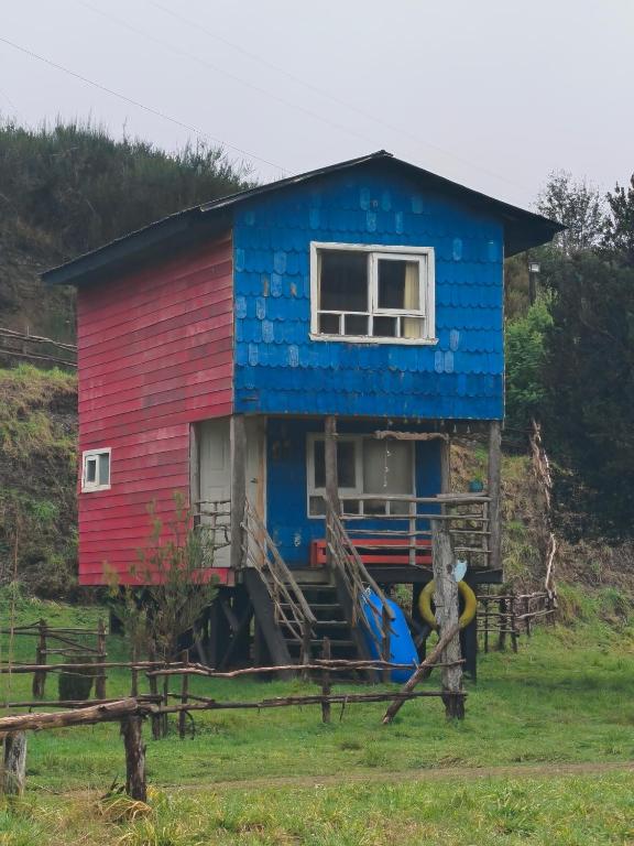 a house that is painted blue and red at Birloche in Pindapulli