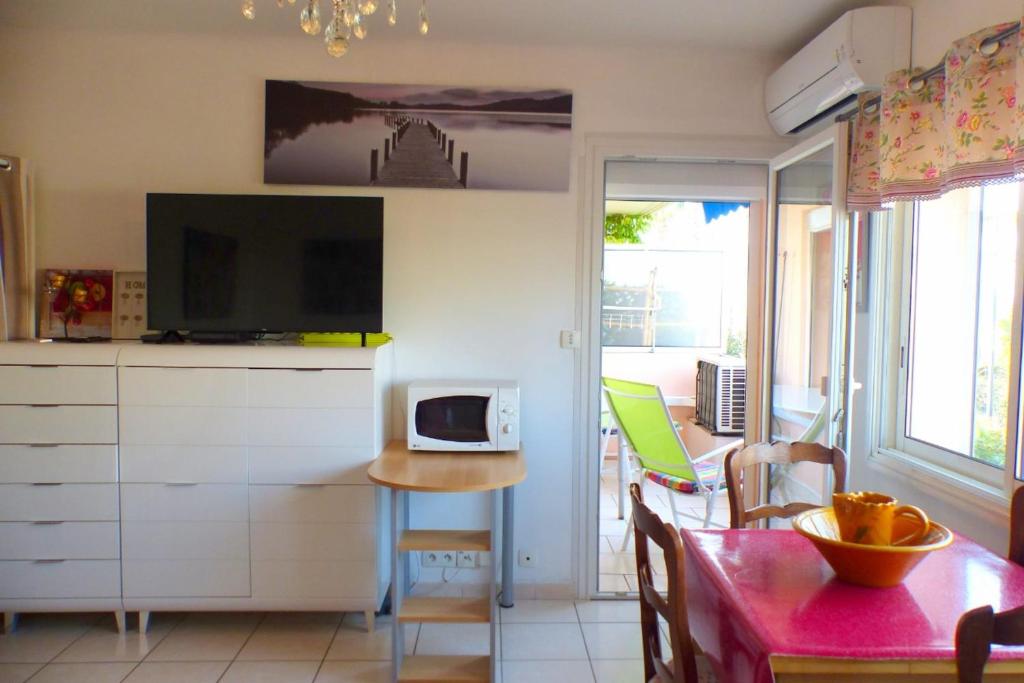 a living room with a kitchen with a table and a tv at Beaches within walking distance private parking! in Six-Fours-les-Plages