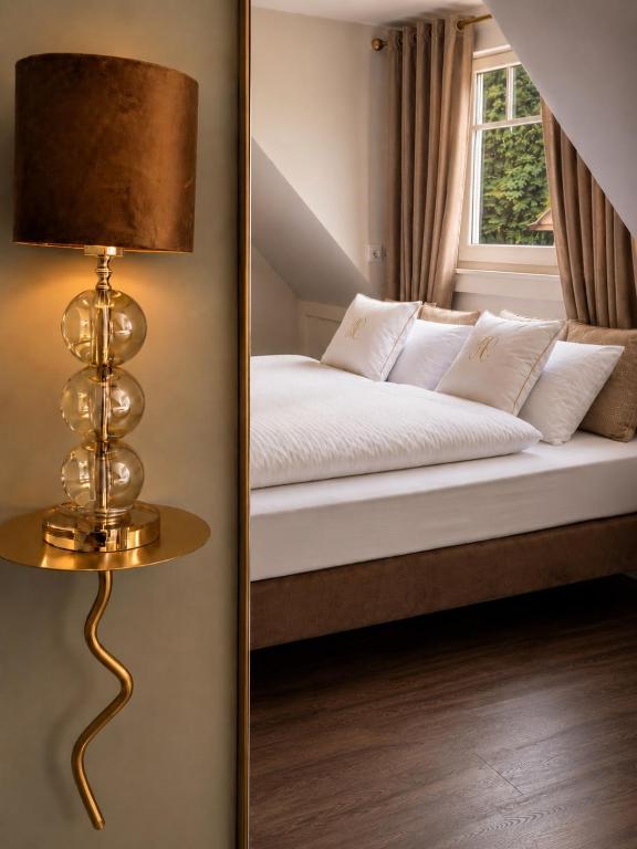 a mirror of a bedroom with a bed and a lamp at Büdel's Spessart Lounge in Lohr am Main