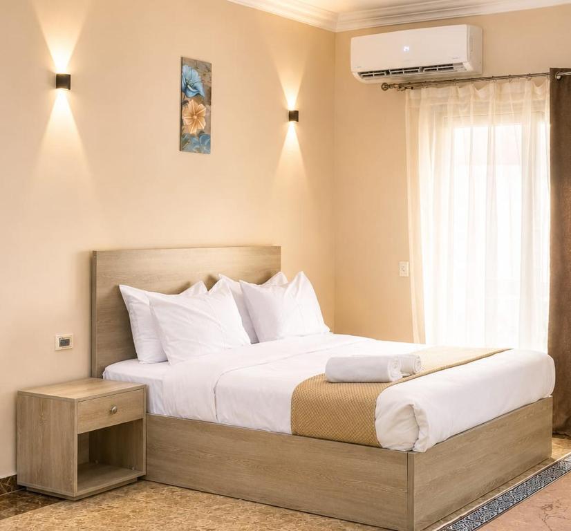 a bedroom with a large bed and a window at Roadhouse New Cairo Residence in Cairo