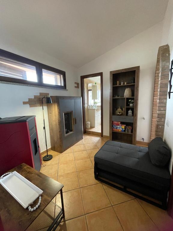 a living room with a black couch and a table at Nenniri's house in Villamassargia