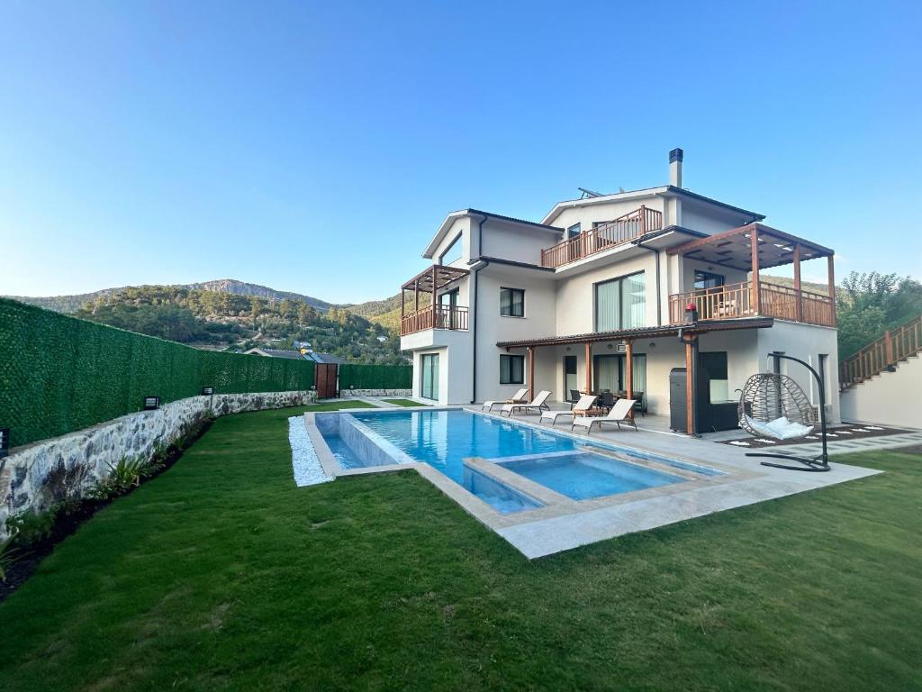 a house with a swimming pool in the yard at Villa Keyf Göcek in Fethiye