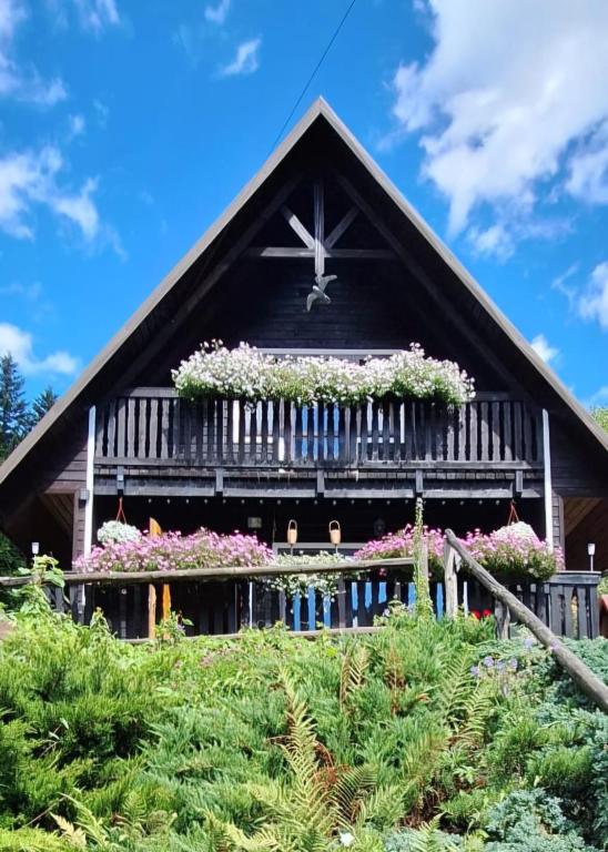 ein Haus mit Blumen an der Vorderseite in der Unterkunft Przytulicha in Bystre