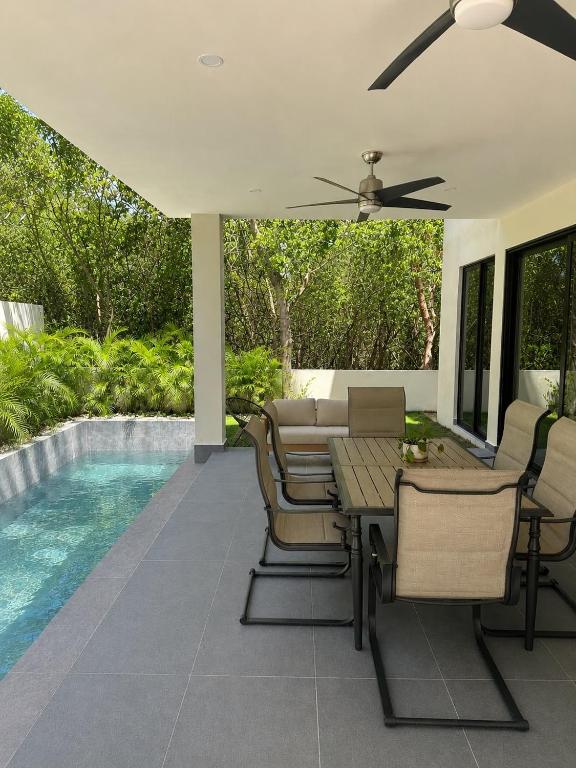 a patio with a table and chairs next to a pool at Villa horizonte in Playa del Carmen