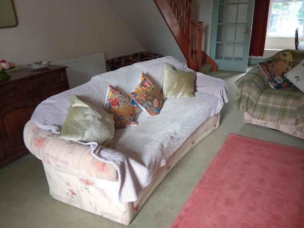 a couch with pillows on it in a living room at lake District cottage in Bootle